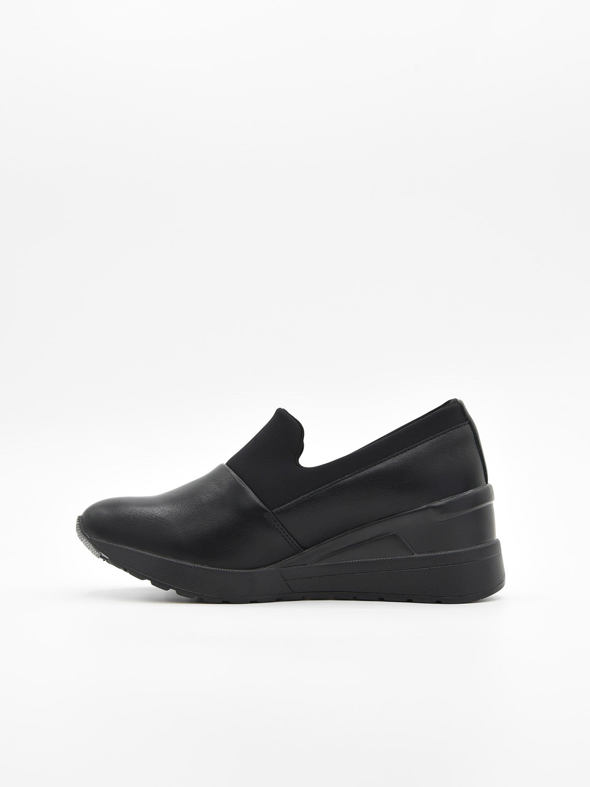 Zapato deportivo de mujer color negro, con diseño slip on sin cordones y suela con cuña interna de plataforma ligera.