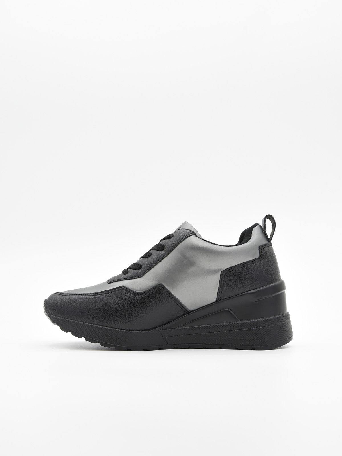 Zapatilla deportiva de mujer negra con cuña interna, detalles en gris metalizado, cordones, logo metálico y suela de plataforma ligera.