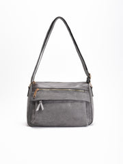 Bolso bandolera gris con solapa, asas medias y varios bolsillos con cremallera. Interior forrado con compartimentos organizadores.