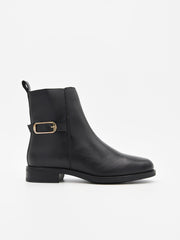 Botines negros con efecto piel, tacón bajo, hebilla lateral dorada y cremallera interior. Diseño elegante y versátil.