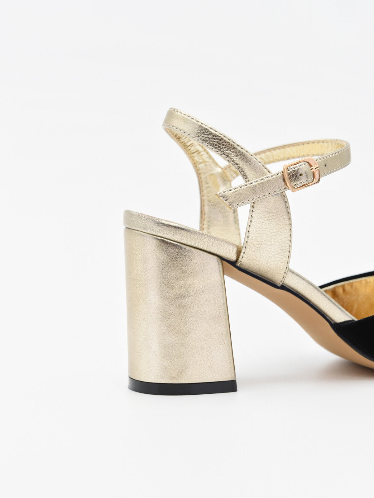 Zapato de terciopelo negro para mujer con tacón ancho dorado metalizado y pulsera ajustable al tobillo.