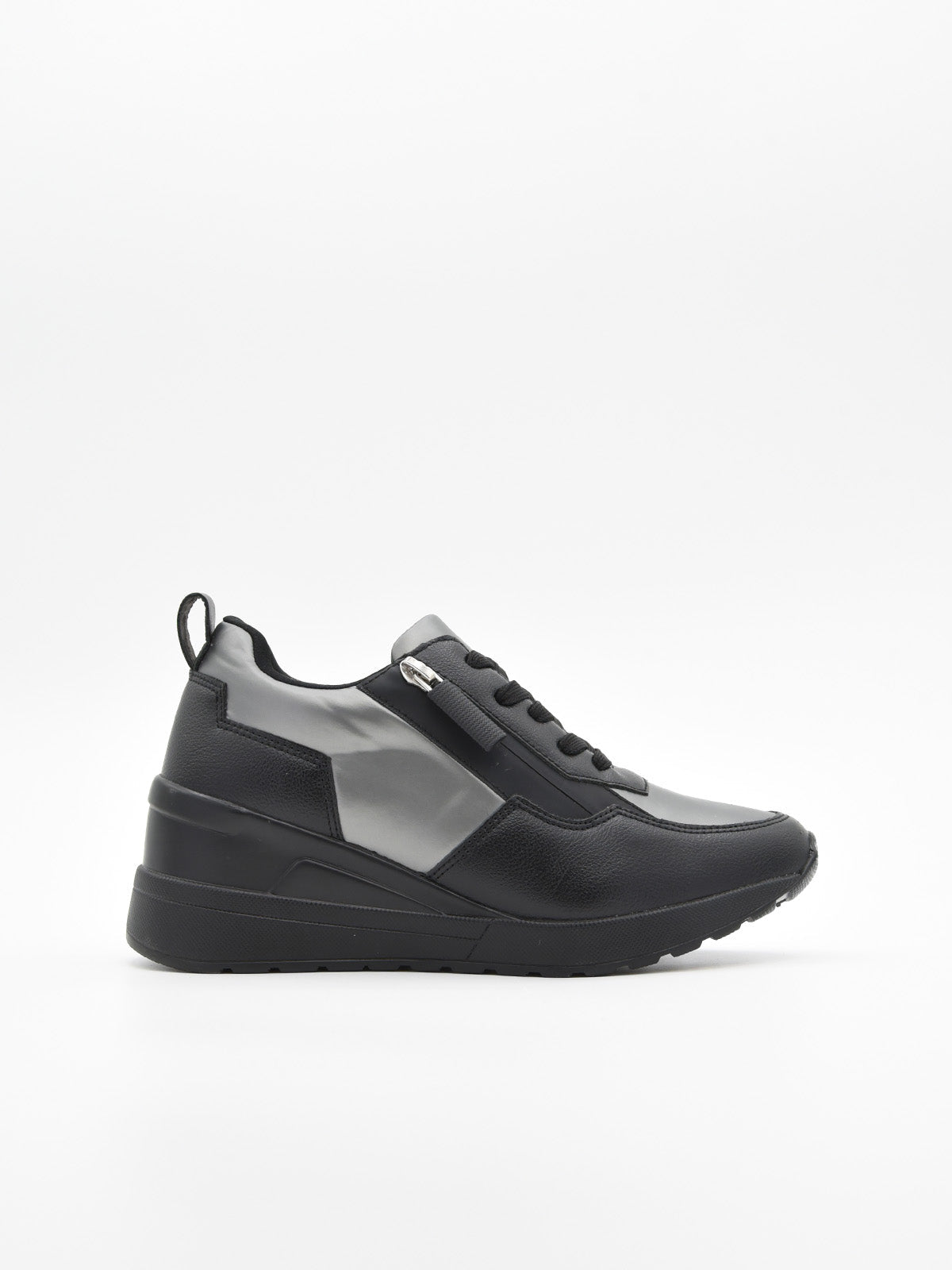 Zapatilla deportiva de mujer negra con cuña interna, detalles en gris metalizado, cordones, logo metálico y suela de plataforma ligera.